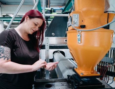 Sarah Berner prüft das Kunstoffgranulat einer Spritzgussmaschine Sarah Berner prüft das Kunstoffgranulat einer Spritzgussmaschine