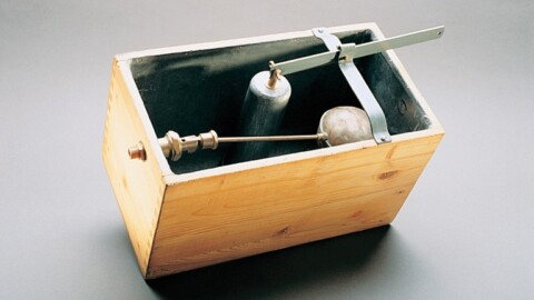 Innenansicht einer hölzernen Toilettenspülkasten-Einheit mit einem Schwimmerventil-Mechanismus.