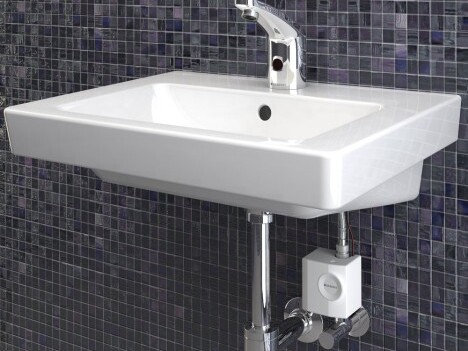 Ein modernes, rechteckiges Waschbecken mit einem glänzenden Wasserhahn, montiert an einer gefliesten Wand.