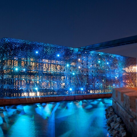 Illuminated modern building with blue lights  at dusk.