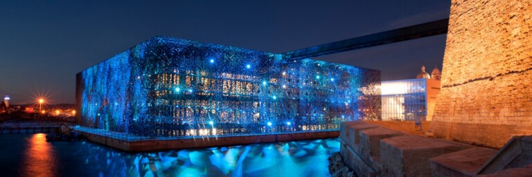 Illuminated modern building with blue lights  at dusk.