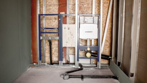 Ein unvollendeter Raum der die Rohrleitungen und Vorwandinstallationssysteme zeigt.