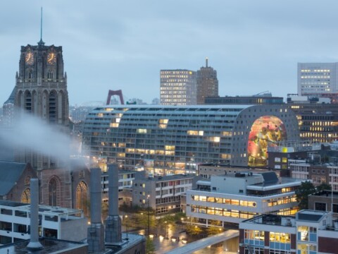 A cityscape showing modern buildings under a cloudy sky.