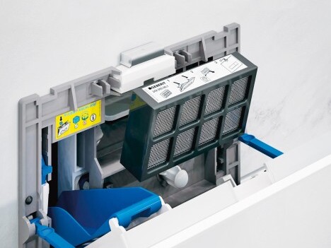 An open appliance drawer showing a removable filter compartment with a black filter.