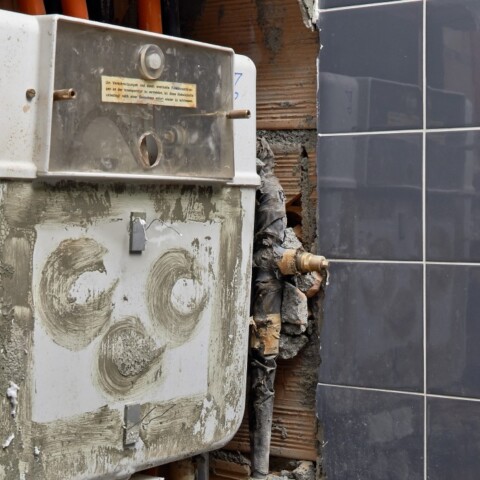 A partially constructed wall and unfinished tiling.