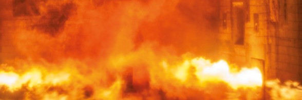 A room engulfed in flames and thick smoke, with a hazy, orange glow.