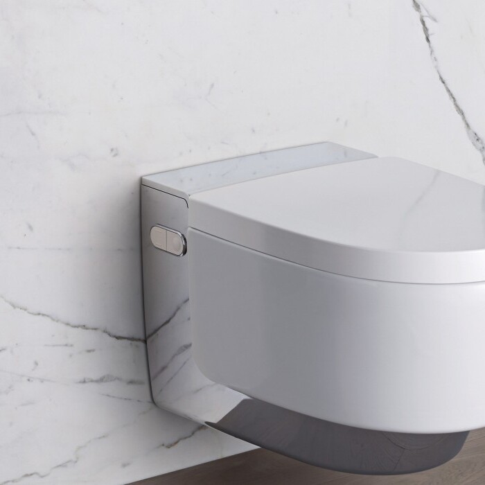 A modern wall-mounted toilet with a sleek design, set against a marble wall.