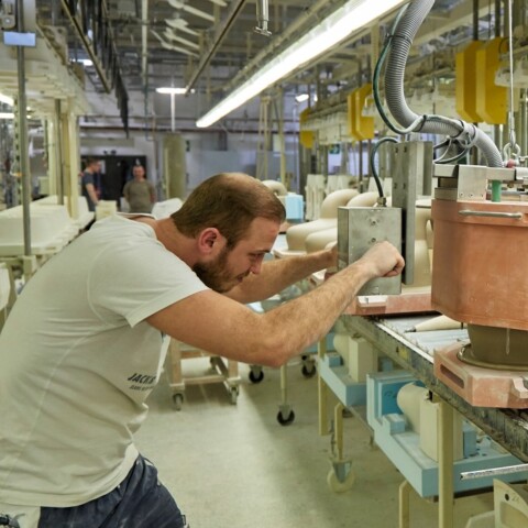 Two workers in a factory that manufacture toilet ceramics.