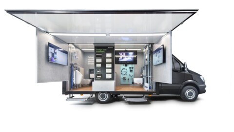 Mobile display truck with open sides, showcasing screens and a modern interior.