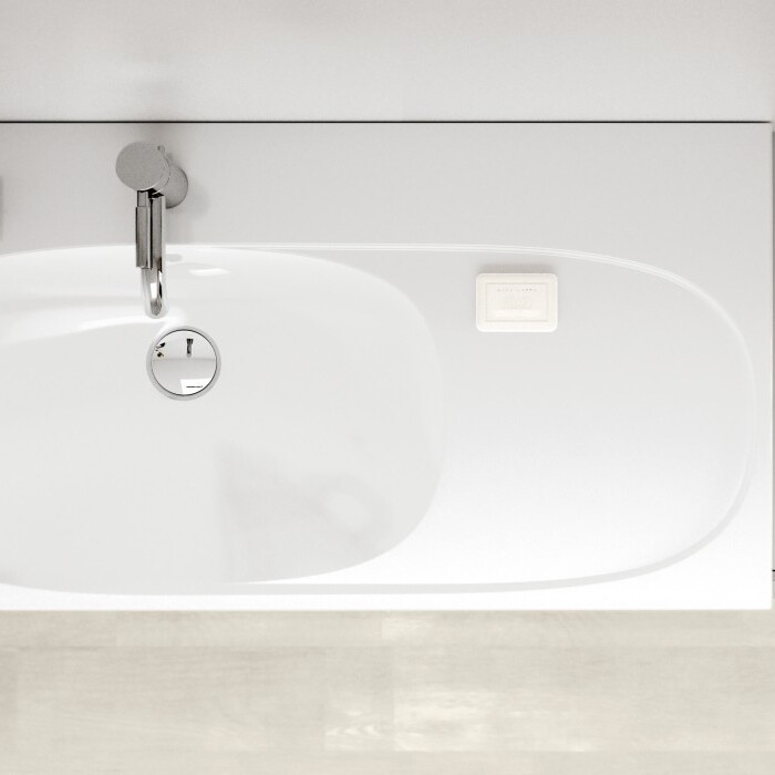 Eine modernes, weisses Waschbecken mit einer silbernen Armatur, daneben ein kleiner Topf mit einer Pflanze und zwei Zeitschriften auf einem grauen Ablagetisch.