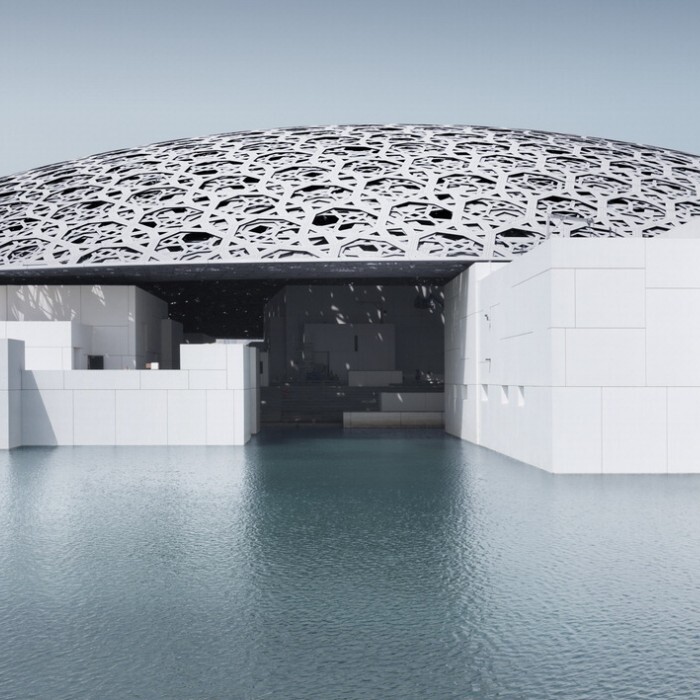 Louvre Abu Dhabi featuring a modern dome structure over a reflective water surface.