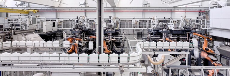 A modern automated manufacturing facility with robotic arms operating along production lines and machinery.