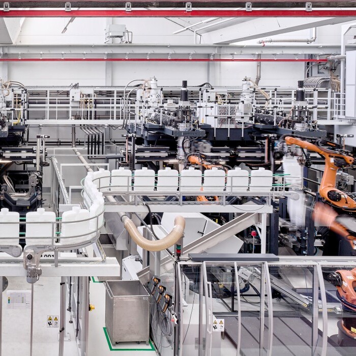 A modern automated manufacturing facility with robotic arms operating along production lines and machinery.