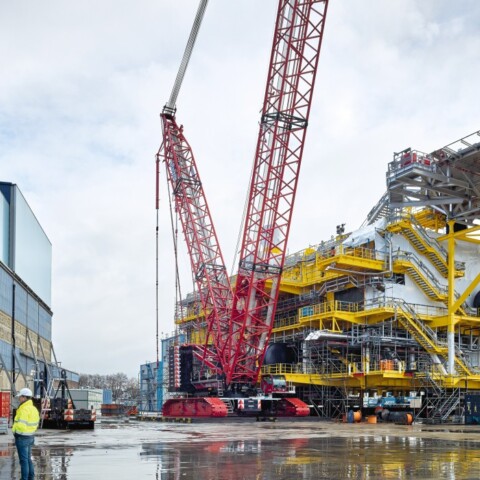Eine grosse Baustelle mit einem Kran und Arbeiter in Schutzkleidung.