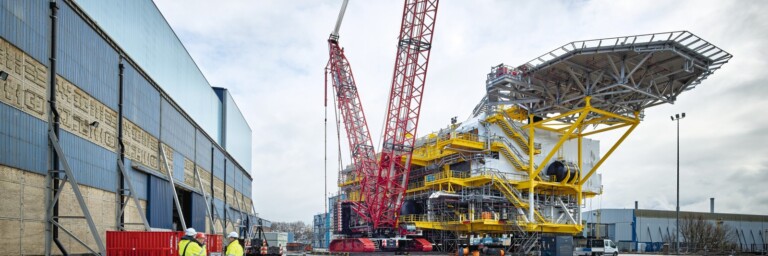 Eine grosse Baustelle mit einem Kran und Arbeiter in Schutzkleidung.