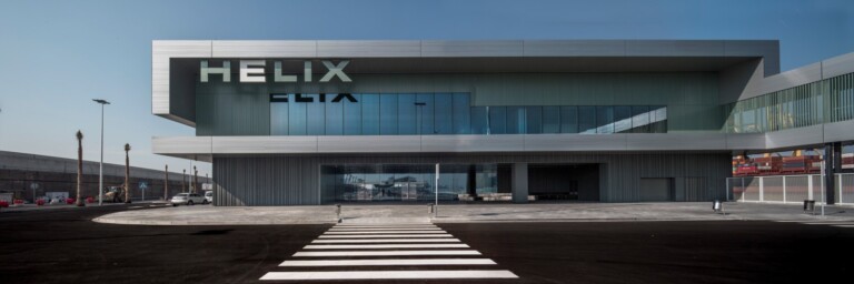 Modern building with large glass windows and "HELIX" signage, viewed from a crosswalk.