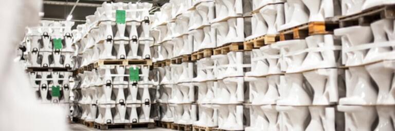 Ein Lager mit mehreren gestapelten Keramiken auf Paletten, die in geraden Reihen angeordnet sind.