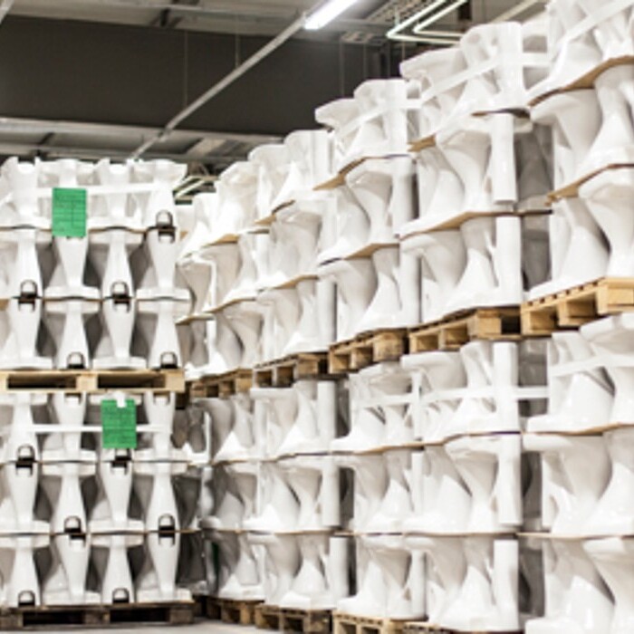 Ein Lager mit mehreren gestapelten Keramiken auf Paletten, die in geraden Reihen angeordnet sind.