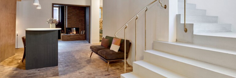 Modernes, stilvolles Interieur mit einer Treppe, einem Couchbereich und einer offenen Atmosphäre.