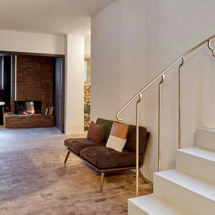 Modernes, stilvolles Interieur mit einer Treppe, einem Couchbereich und einer offenen Atmosphäre.