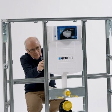 A person adjusting a plumbing installation within a metallic frame.