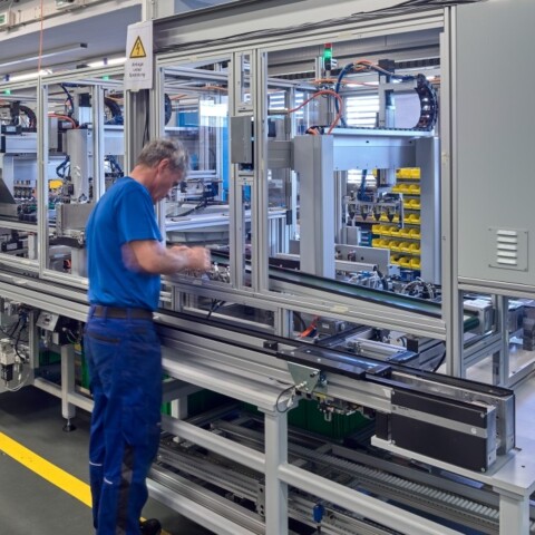 Männer in blauer Uniform arbeiten an Maschinen.