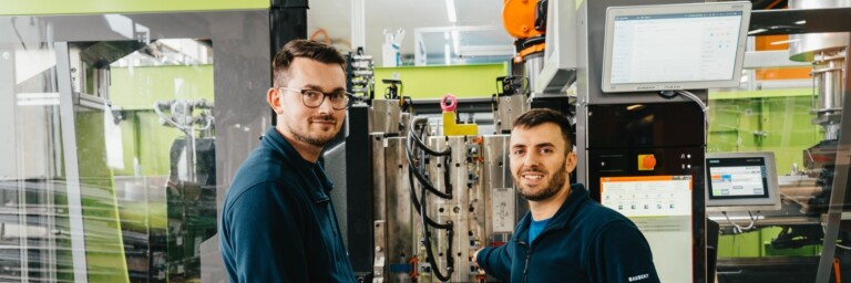 Bild von Hamid Isič und Mevljudin Memedi vor einer Spritzgussanlage