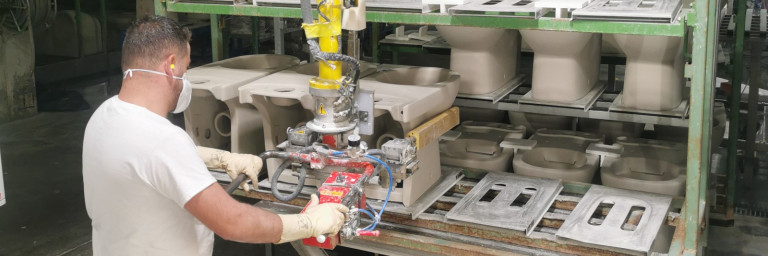 Ein Mitarbeiter entlädt die Keramiken ohne physischen Kraftaufwand, dank einer Hebehilfe.