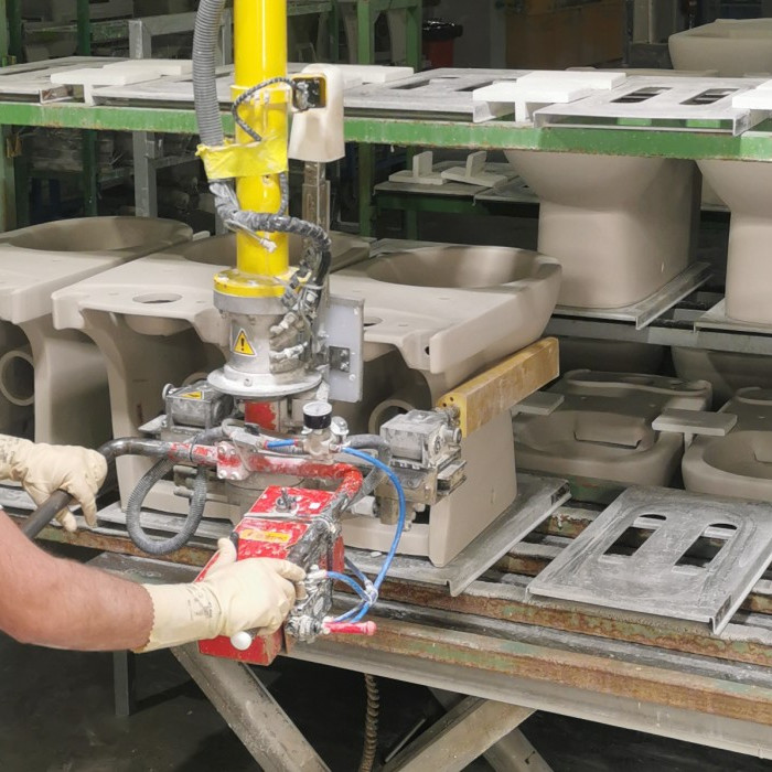 Ein Mitarbeiter entlädt die Keramiken ohne physischen Kraftaufwand, dank einer Hebehilfe.