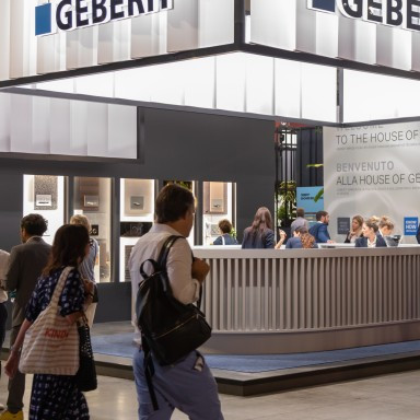 Messestand von Geberit mit Besuchern und prominenter Firmenbeschilderung.