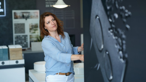 Zorana Stojanović präsentiert den ausziehbaren Schrank mit Geberit Betätigungsplatten.