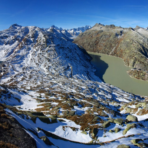 A panoramic view of snow-covered mountains with lakes.