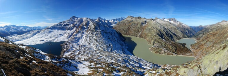 A panoramic view of snow-covered mountains with lakes.