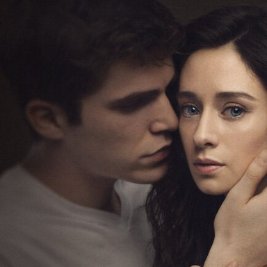 Ein junger Mann umarmt eine Frau sanft in einer emotional geladenen Atmosphäre.