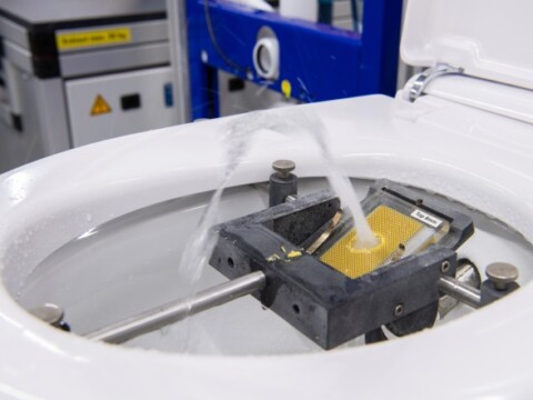 Ein Laborgerät mit einem Wassersprühmechanismus, mit sichtbaren Komponenten und Maschinen im Hintergrund.