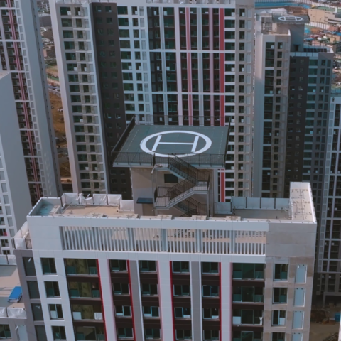 Moderne Hochhäuser mit Hubschrauberlandeplätzen und urbanem Hintergrund.