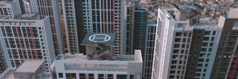 Moderne Hochhäuser mit Hubschrauberlandeplätzen und urbanem Hintergrund.