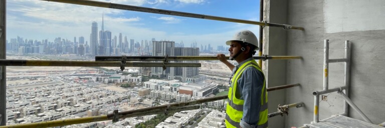 Über den Dächern von Dubai: Vineet Kumar Bhaskar auf einer Baustelle. Im Hintergrund die Skyline von Dubai.