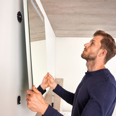 Der Spiegel wird in der Halterung eingehängt und festgedrückt. Beim Entfernen des Spiegels haften die Clips an der Wand.