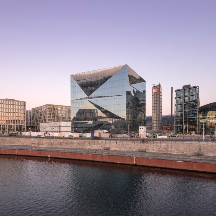 Modern urban skyline featuring contemporary buildings along a waterfront at dusk.