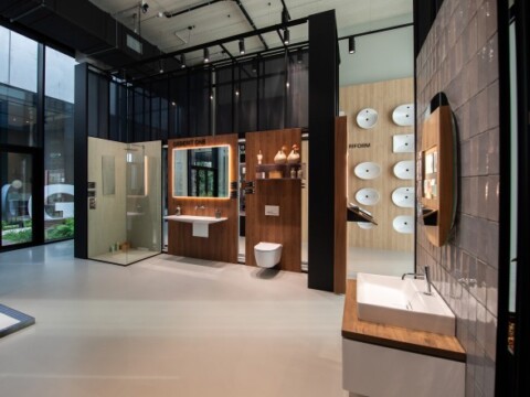 Modern bathroom showroom featuring various fixtures, including sinks, toilets, and mirrors, arranged in a contemporary space.