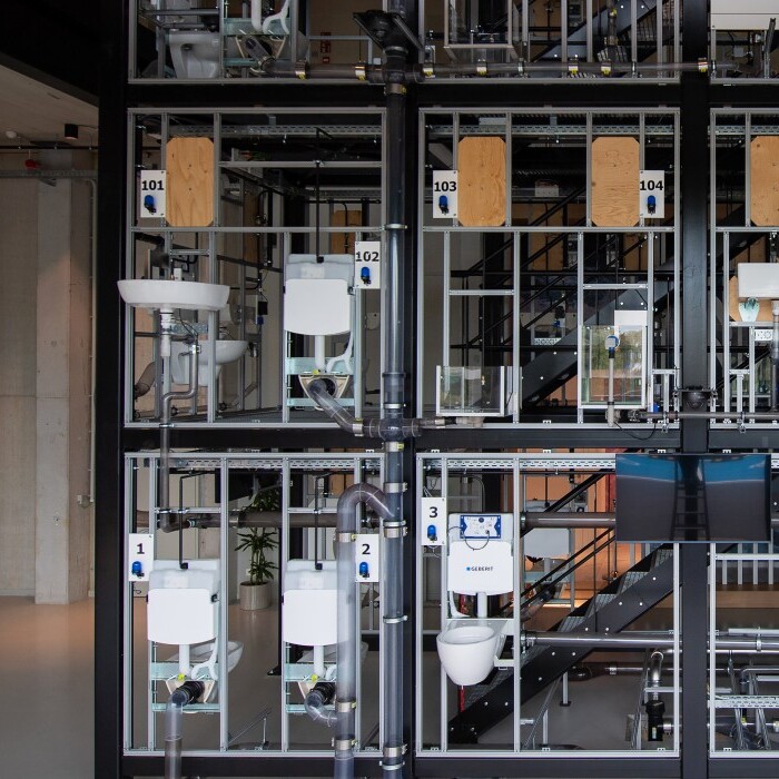 A modular display of interconnected mechanical components and frames, showcasing various sanitary equipment arranged in a grid-like structure.