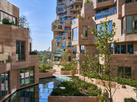 Modern architectural buildings with numerous windows, surrounded by greenery.