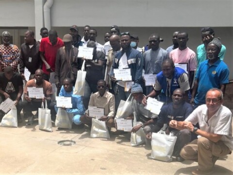 Eine Gruppe von Männern hält Zertifikate in der Hand.