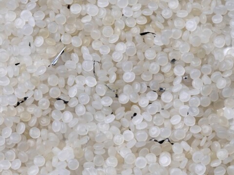 Small white plastic pellets or beads scattered on a surface.