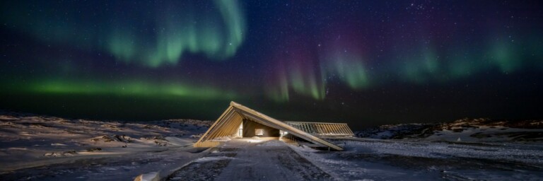 The Icefjord Centre in the spectacular northern lights of the Greenlandic polar night.