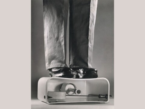 Eine Person mit Schuhen steht auf einem Spülkasten.