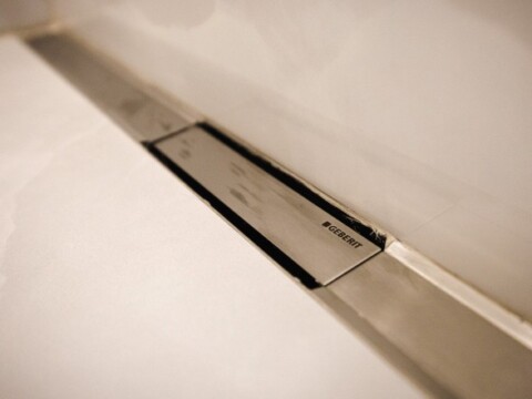 Eine schmale, moderne, eingebaute Duschrinne.