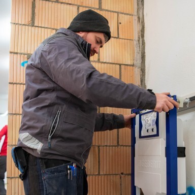 Ein Handwerker installiert einen Duofix an die Wand.