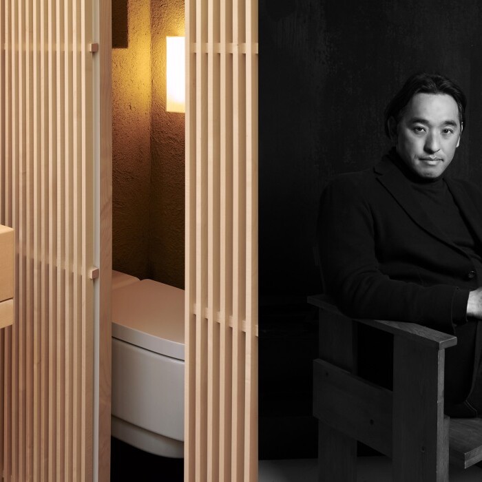 A modern wooden bathroom featuring a sleek sink and ambient lighting, alongside a black-and-white portrait of a man seated thoughtfully.